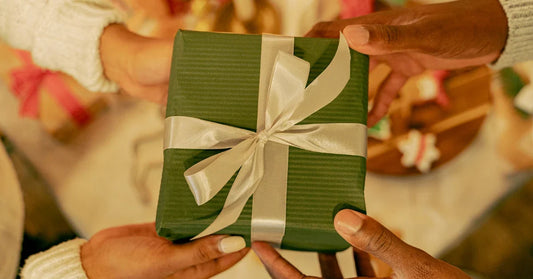 Person giving a wrapped Rakhi gift to his sister during Raksha Bandhan.